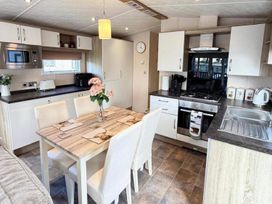 A kitchen with table and chairs at Lillardsedge Luxury Caravan Sleeps 6 with Parking near Lilliardsedge Holiday Park