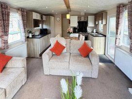 A living room with a sofa and kitchen unit at Lillardsedge Luxury Caravan Sleeps 6 with Parking Lilliardsedge Holiday Park near St Boswells