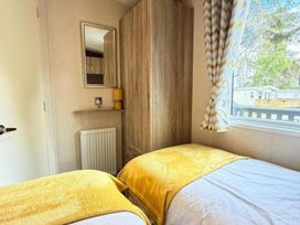 A bedroom with two beds and a wardrobe at Lillardsedge Luxury Caravan Sleeps 6 with Parking Lilliardsedge Holiday Park near St Boswells