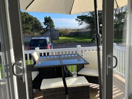 An outdoor seating area with a table and chairs at Surfside Bliss Cayton Bay Park caravan Cayton Bay