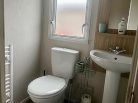 A bathroom with a toilet and sink at Surfside Bliss Cayton Bay Park caravan Cayton Bay
