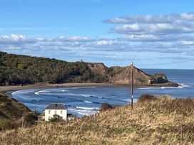 A coastal view with a house near the sea at Surfside Bliss Cayton Bay Park caravan in Cayton Bay