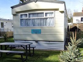 A mobile home with a welcome sign and outdoor table at Woodland View Dog Friendly Nr Sutton on Sea in Thurlby near Alford