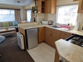A kitchen with a refrigerator, stove, and sink at Woodland View Dog Friendly Nr Sutton on Sea Thurlby near Alford