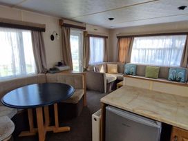 A living room with a table and sofa at Woodland View Dog Friendly Nr Sutton on Sea Thurlby near Alford