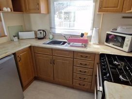 A kitchen with appliances and a sink at Woodland View Dog Friendly Nr Sutton on Sea Thurlby near Alford
