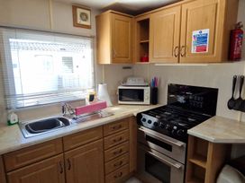 A kitchen with a sink, oven, and microwave at Woodland View Dog Friendly Nr Sutton on Sea Thurlby near Alford