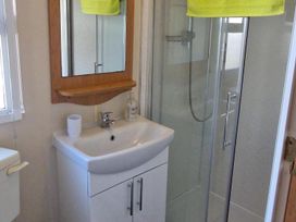 A bathroom with a sink, shower, and mirror at Woodland View Dog Friendly Nr Sutton on Sea in Thurlby near Alford