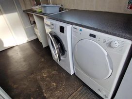 A laundry room with washing machine and tumble dryer at Woodland View Dog Friendly Nr Sutton on Sea Thurlby near Alford