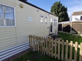 A mobile home with a fenced area and outdoor seating at Woodland View Dog Friendly Nr Sutton on Sea, Thurlby near Alford