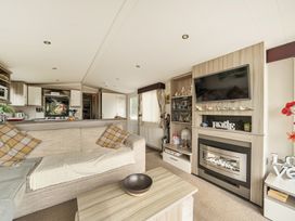 A living room with a sofa and television at The Old Barn in Tunstall, North Yorkshire