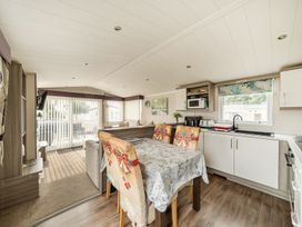A living room with a dining table and kitchenette at a property in Tunstall, North Yorkshire
