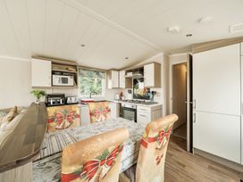 A kitchen with appliances and dining area at the property in Tunstall, North Yorkshire