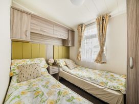 A bedroom with two beds and curtains at The Old Barn in Tunstall, North Yorkshire