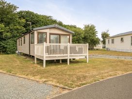 A mobile home with a deck in an outdoor area at Tunstall, North Yorkshire