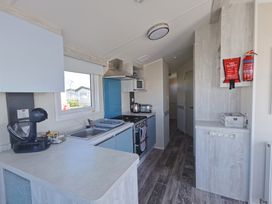 A kitchen with sink, cabinets, stove and microwave at 