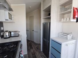 A kitchen with stove, fridge, and appliances at The Old Barn in Manchester