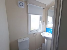 A bathroom with toilet, sink, and window at the property in location
