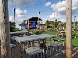 An outdoor area with a stage and picnic tables at an unspecified location