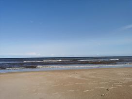A beach with sand and waves at the ocean