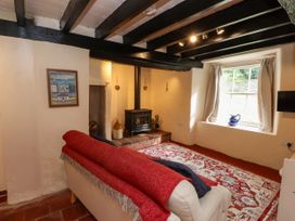 A living room with a sofa and stove at Felin Bach in Aberdaron