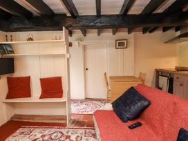A living room with a sofa, table, and chairs at Felin Bach in Aberdaron