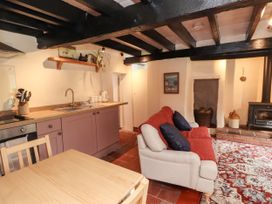 A kitchen with sink, stove, and sofa at Felin Bach in Aberdaron