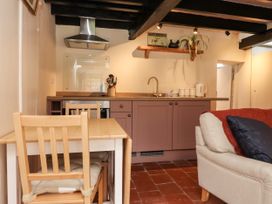 A kitchen with cabinets and a table at Felin Bach in Aberdaron