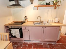 A kitchen with a stove and sink at Felin Bach in Aberdaron