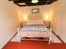 A bedroom with a bed and bedside tables at Felin Bach Aberdaron