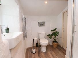 A bathroom with a sink, toilet and towel warmer at Felin Bach in Aberdaron