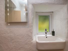 A bathroom with a sink and a window at Felin Bach Aberdaron