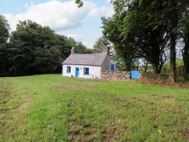 A cottage surrounded by grass and trees at Felin Bach Aberdaron