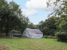 A house surrounded by trees and grass at Felin Bach Aberdaron