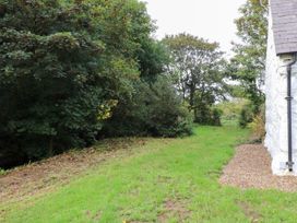 A garden with grass and trees at Felin Bach Aberdaron