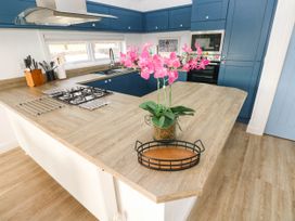 A kitchen with an island countertop and gas stove at Pleasant Valley Holiday Lodge 70 Stepaside