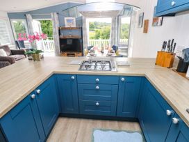 A kitchen with a stove and table at Pleasant Valley Holiday Lodge 70 Stepaside