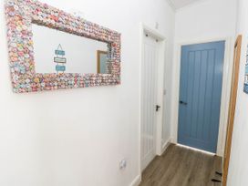 A hallway with a decorative mirror and doors at Pleasant Valley Holiday Lodge 70 Stepaside