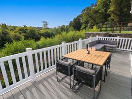 A deck with a table and chairs at Pleasant Valley Holiday Lodge 70 Stepaside