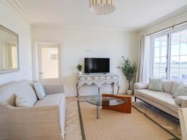 A living room with a television and two sofas at 30 Southdown Avenue Weymouth