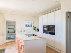 A kitchen with a kitchen island and bar stools at 30 Southdown Avenue, Weymouth