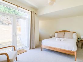 A bedroom with a bed and large windows at 30 Southdown Avenue Weymouth
