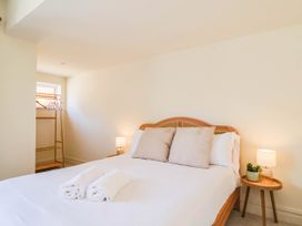 A bedroom with a bed and a clothes rack at 30 Southdown Avenue Weymouth