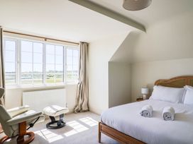 A bedroom with a bed and armchair at 30 Southdown Avenue, Weymouth