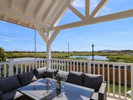 An outdoor patio with a table and couch overlooking a landscape at 30 Southdown Avenue Weymouth