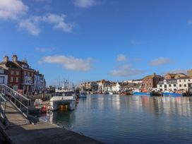 A harbor with boats and buildings by the water at 30 Southdown Avenue in Weymouth
