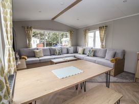 A living room with a sofa and dining table at S7 Abergele