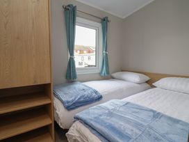 A bedroom with two beds and a window at S7 Abergele