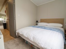 A bedroom with a bed and nightstand at S7 in Abergele