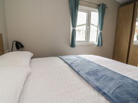 A bedroom with a bed and curtains at S7 in Abergele